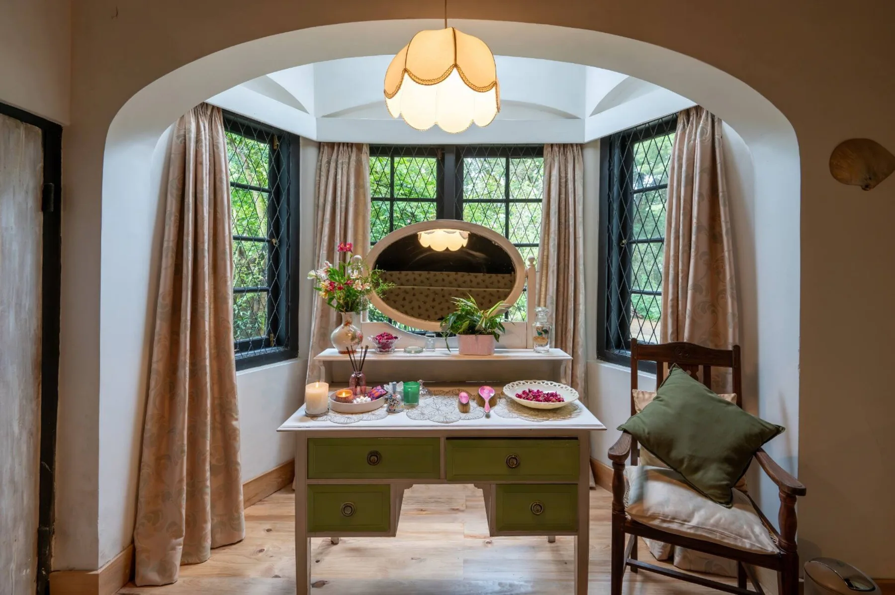 A vintage dresser beneath the bedroom’s arched bay window