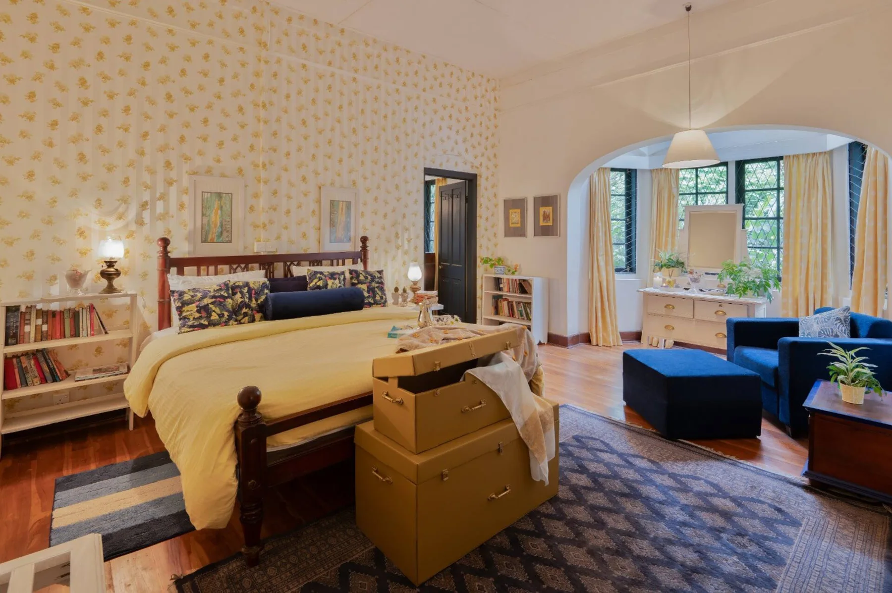 Selwood’s sunny yellow bedroom with a bay window and blue chairs